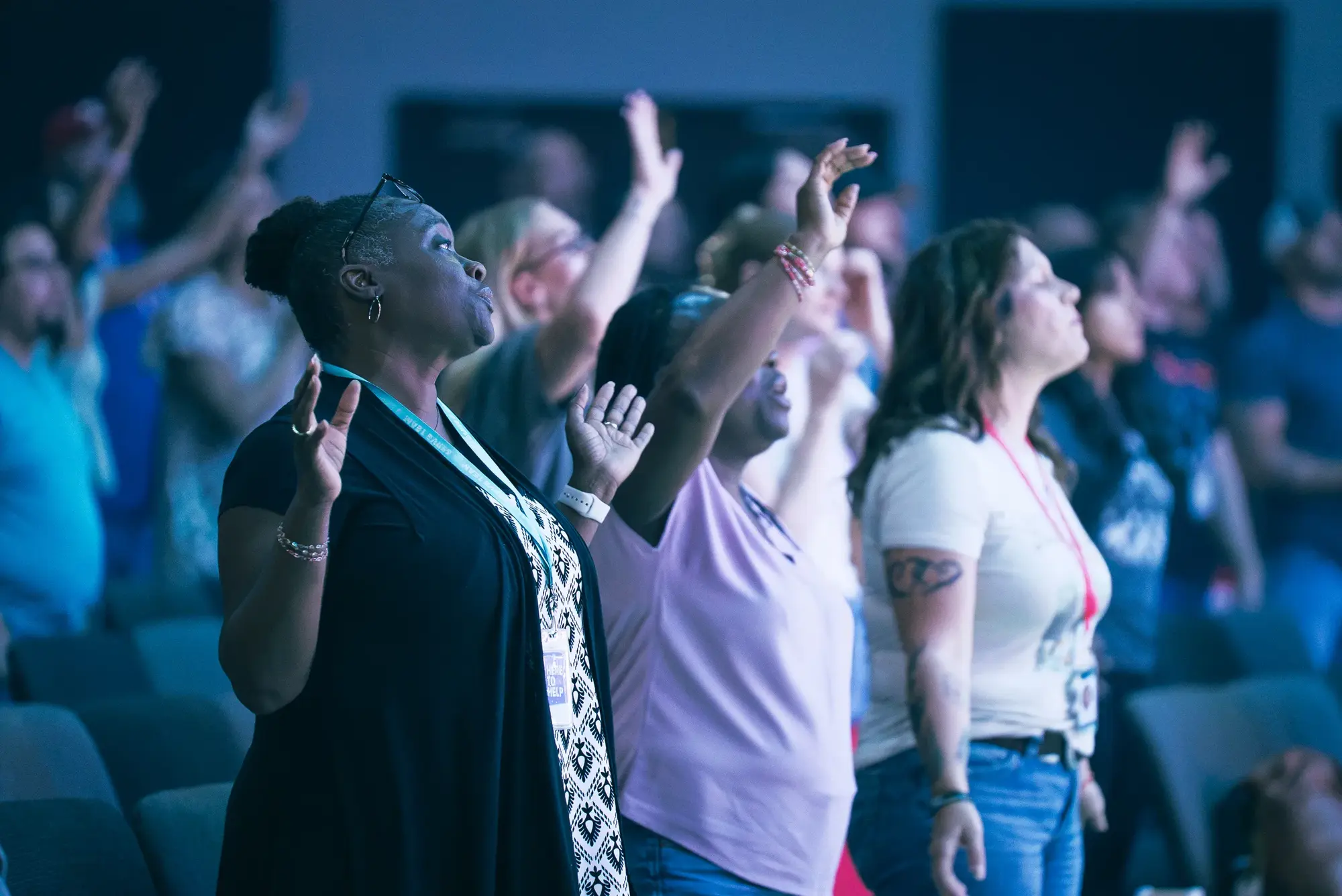 A room of people worshipping with hands raised at a midweek gathering