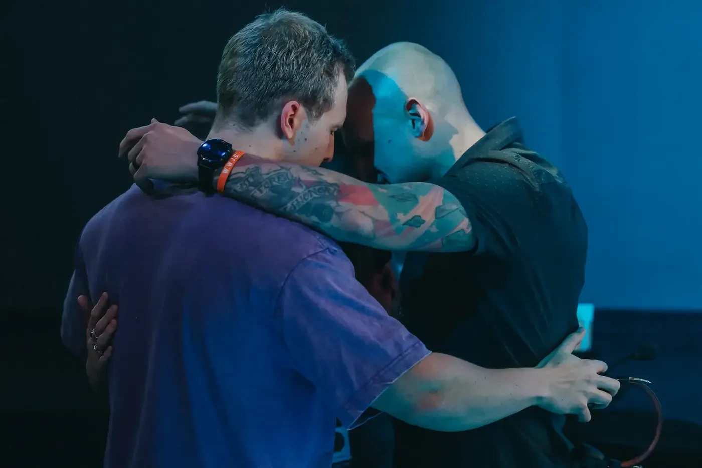 Two men embracing in prayer during worship